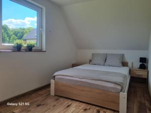 a bedroom with a bed and a large window at Domek na Sowiej in Kłodzko