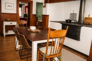 a kitchen with a wooden table and a table and chairs at Albert Manor guest house in Ladismith