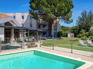 a swimming pool in front of a building at ibis Salon de Provence in Salon-de-Provence