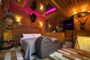 a bedroom with a bed in a room with wooden walls at Motel Venus Madrid Norte in Meco