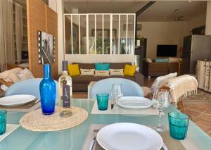 a blue table with plates and a bottle of wine at Villa des Delices in Grimaud