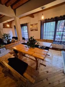 a large living room with a wooden table and chairs at Cozy Cottage Vlašić in Vlasic