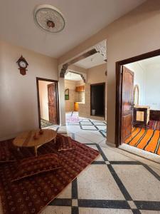 a living room with a table in the middle of a room at Sunlight guest house in Taghazout