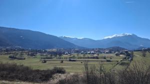 a view of a field with mountains in the background at Sunset House Sarajevo in Sarajevo