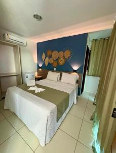 a bedroom with a large bed and a blue wall at Pousada Maragolfinho in Maragogi