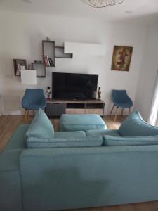 a living room with a blue couch and two blue chairs at Superbe maison proche de Paris! in Sceaux