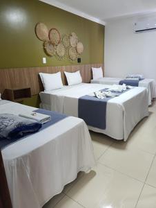 a group of three beds in a room at Pousada Maragolfinho in Maragogi