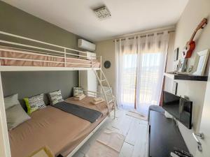 a bedroom with a bunk bed and a television at Boho Mare Retreat - Skala Fourkas in Skala Fourkas