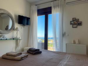 a bedroom with a large bed with a large window at Boho Mare Retreat - Skala Fourkas in Skala Fourkas