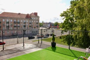 a balcony with a green lawn in front of a building at Bohemia Jacuzzi & Sauna Apartment in Klaipėda +24 photos