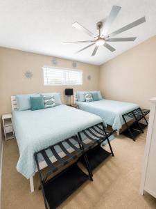 a bedroom with two beds and a ceiling fan at The Little Penthouse in Lake Ozark +31 photos