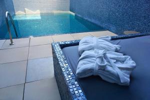 a bath tub with a towel sitting next to a swimming pool at Motel Venus Madrid Norte in Meco