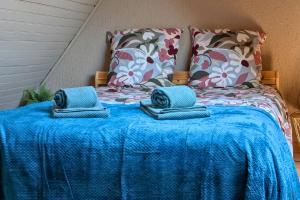 a bed with a blue blanket and pillows on it at Spacious Loft - Quiet and Bright in Soultz-Haut-Rhin