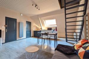 a living room with a staircase and a table and chairs at Spacious Loft - Quiet and Bright in Soultz-Haut-Rhin