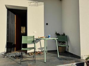 a table and two green chairs in a room at TwinSeas in Draç