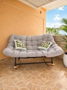 a gray couch with two pillows on a patio at Villa Sea La Vie in Utjeha