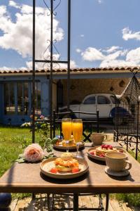 a wooden table with food and two glasses of orange juice at Ô Dentelles in Vacqueyras