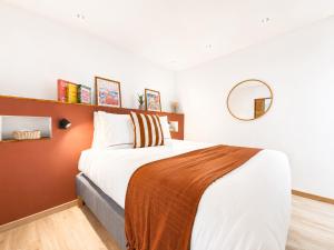 a bedroom with a large bed and a mirror at Le Chabeuillois in Chabeuil