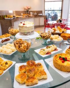 a table filled with different types of pastries and cakes at Granterrara Hotel in Jequié