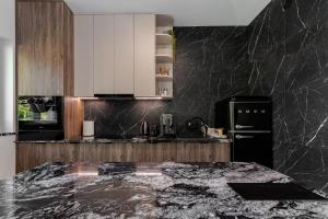 a kitchen with black marble countertops and a black refrigerator at Marina Dziwnów Premium Haus 2 in Dziwnów