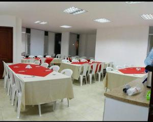 a room with tables and chairs with red napkins on them at Hotel Milán in Duitama