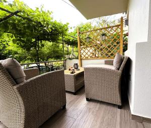 a patio with two wicker chairs and a table at My Afytos Garden in Afitos