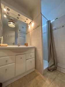 a bathroom with a sink and a shower and a mirror at Appartement frejus in Fréjus +12 photos