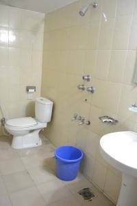 a bathroom with a toilet and a sink and a bucket at Hotel Marine Plaza in Cox's Bazar