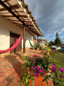 a patio with a hammock and some flowers at Cabaña VillaMaria in Villanueva