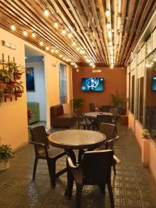a waiting room with tables and chairs and a tv at Hotel Milán in Duitama