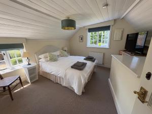 a bedroom with a bed and a flat screen tv at Stunning 3 bedroom 3 bath self catering cottage nr Stonehenge, Salisbury, Longleat, Avebury and Bath, Short walk to lovely village pub in Pewsey