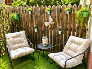 two chairs and a table in front of a fence at La Marmotte appartement cosy centre Briancon proche Prorel in Briançon