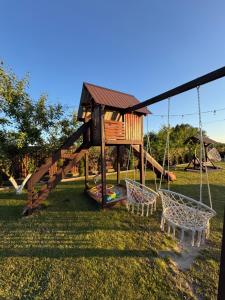 a playground with a swing and two chairs at Маєток Мигдаль in Svityazʼ