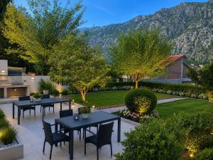 a patio with tables and chairs and a garden at Kotor Bay View Residence with Pool in Muo