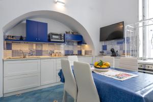a kitchen with a table with a bowl of fruit on it at Levante - charming apartment with sea-view terrace, fits up to 7 guests in Maiori