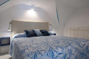 a bedroom with a large bed with blue pillows at Levante - charming apartment with sea-view terrace, fits up to 7 guests in Maiori