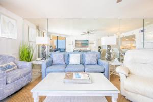 a living room with blue couches and a table at Phoenix V 916 in Orange Beach