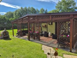 a wooden pavilion in a yard with grass at Bajkowy Las in Pobierowo