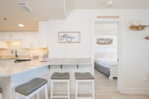 a kitchen with a counter and stools in a room at Phoenix V 916 in Orange Beach