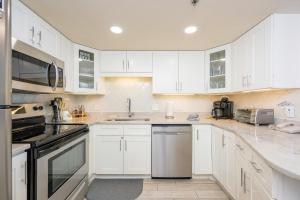 a white kitchen with white cabinets and appliances at Phoenix V 916 in Orange Beach