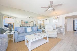 a living room with a blue couch and a table at Phoenix V 916 in Orange Beach