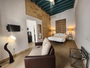 a living room with a bed and a couch at CAMASanlúcar in Sanlúcar de Barrameda