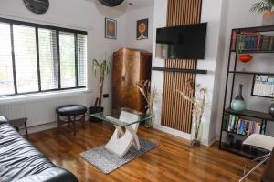 a living room with a couch and a glass table at Century Apartments Manchester in Dukinfield