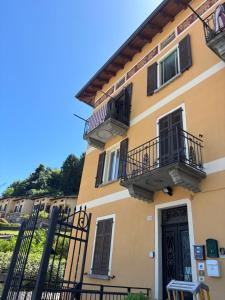 a yellow building with balconies and a door at Charming & bright apartment Como lakefront in Argegno