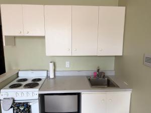 a kitchen with white cabinets and a stove and a sink at Apex Residence The Lake Merrit Hause in Oakland
