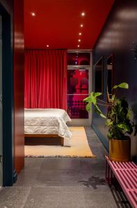 a bedroom with a bed and a red curtain at Hotel Hilo - Room 102 in Louisville