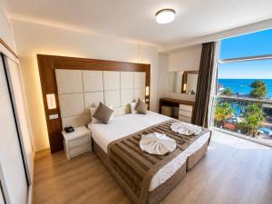 a bedroom with a large bed and a large window at Delfino Apart Hotel in Alanya +37 photos