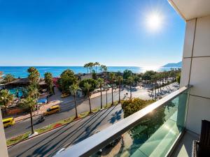 a view from the balcony of a building with a street and the ocean at Delfino Apart Hotel in Alanya