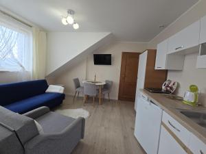 a kitchen and living room with a couch and a table at Mirato in Władysławowo