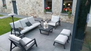 a patio with a couch and chairs and a table at Chambre à TROOZ dans magnifique fermette - très calme, jacuzzi - 40 minutes de Spa - Francorchamps in Trooz +24 photos